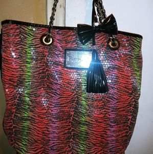 A colorful shoulder bag with pink interior.